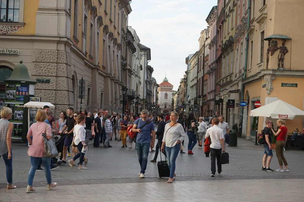 Turyści na ulicy przy Rynku Głównym w Krakowie